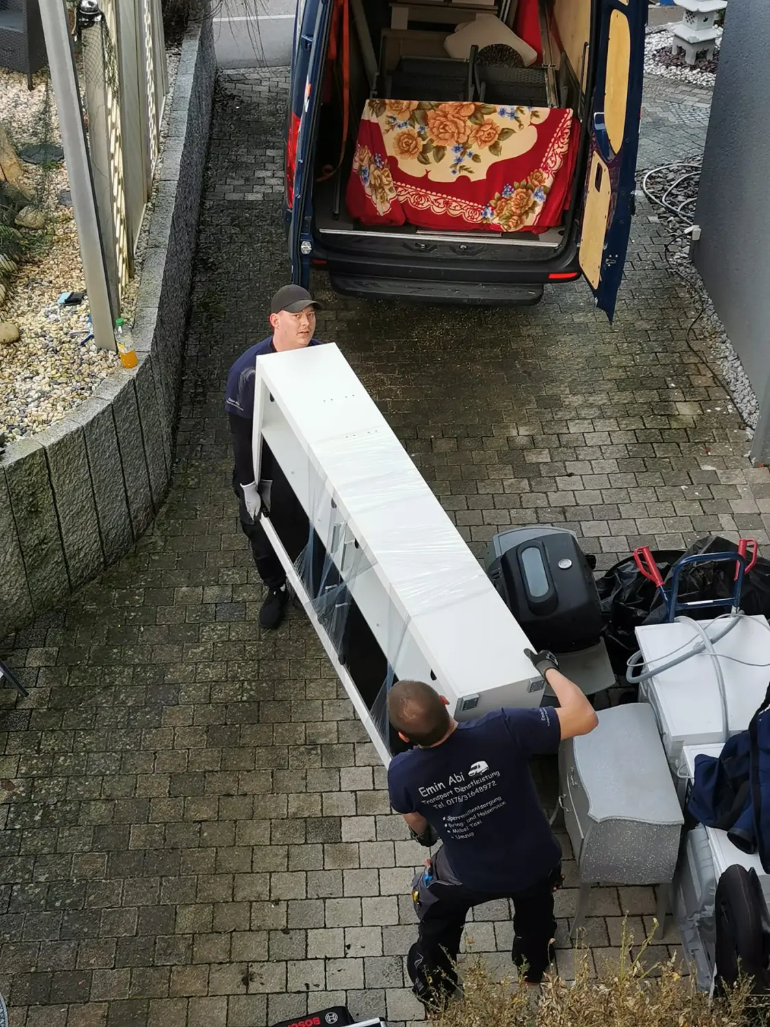 Mann trägt Gepäck von Emin Abi Transporte
